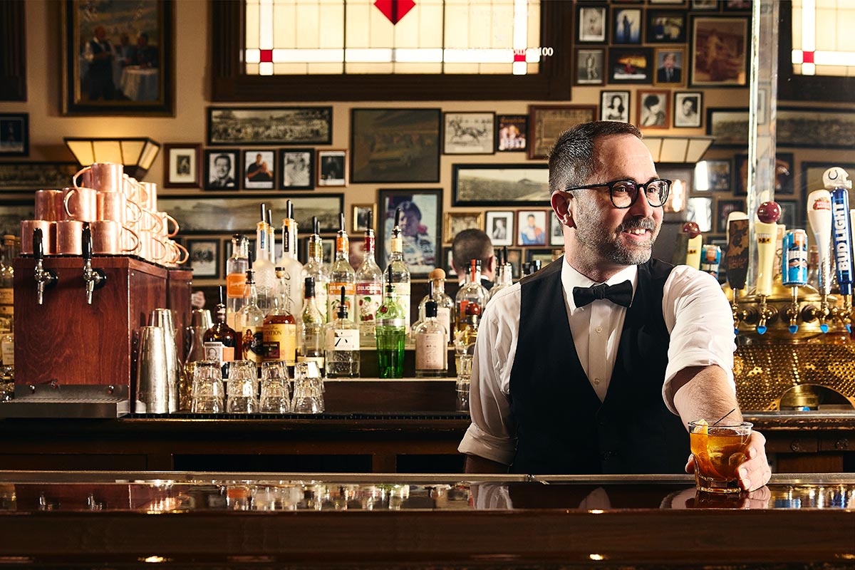 Bartender serving a cocktail inside St. Elmo Steak House